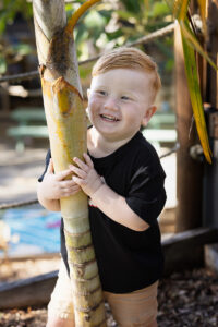 Smiling boy playing in a garden for his childcare photo in Coombabah