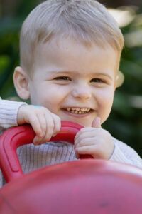 Happy boy enjoying play with a bouncy ball during natural early learning photography in North Brisbane childcare centre